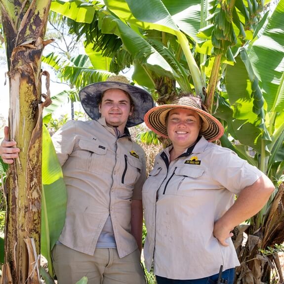 two people standing next to a tree