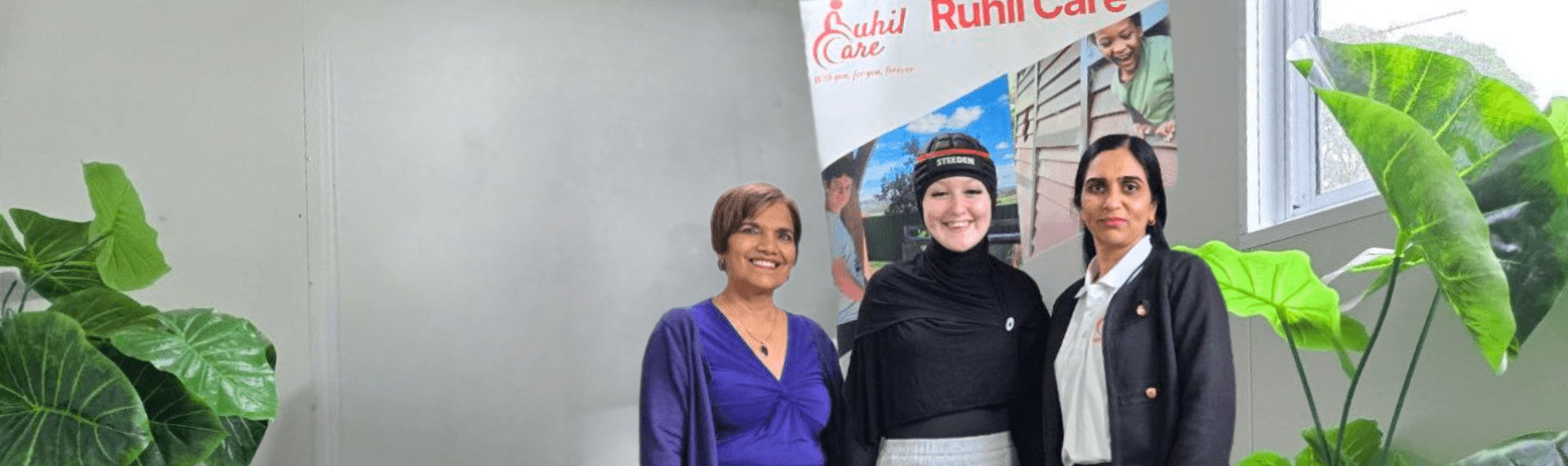 three women standing next to a sign