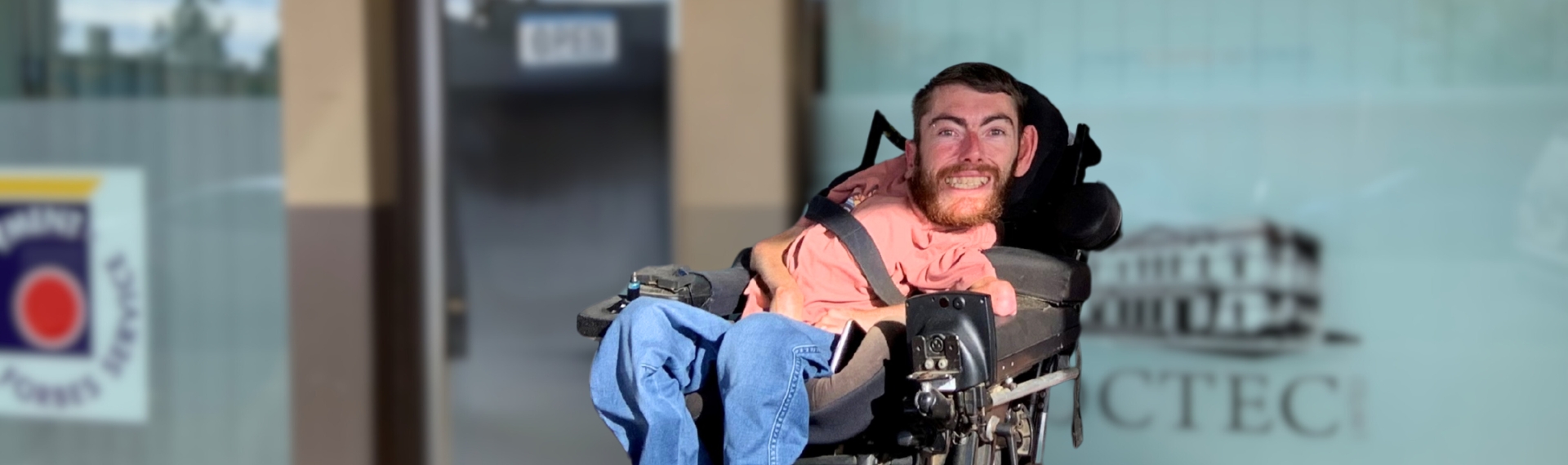 Man in wheelchair outside building.